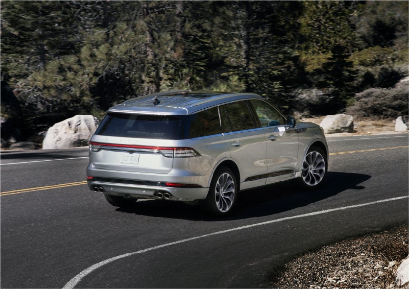 A 2023 Lincoln Aviator® Grand Touring model is shown being driven on a tight turn of a mountain road | Empire Lincoln of Huntington in Huntington NY