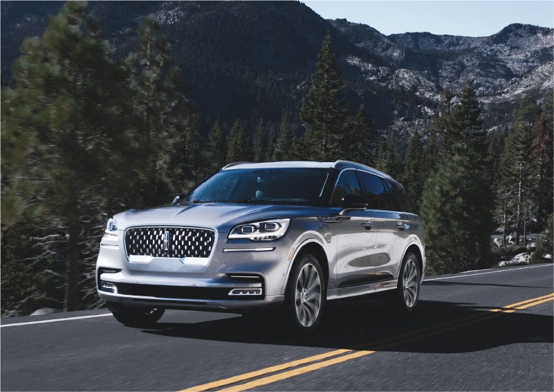 A 2023 Lincoln Aviator® Grand Touring SUV being driven on a winding road to demonstrate the capabilities of all-wheel drive | Empire Lincoln of Huntington in Huntington NY