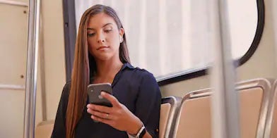 Ladie on a metro looking at her phone