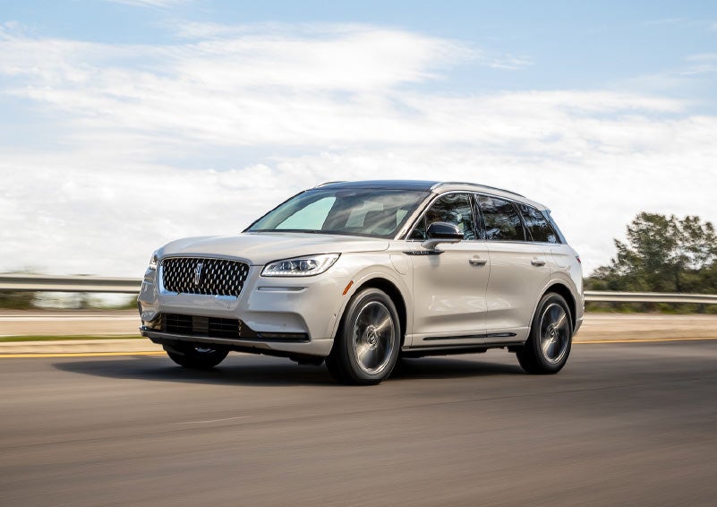 A Lincoln Corsair Grand Touring is shown being driven along a scenic roadway