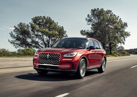 A 2024 Lincoln Corsair® SUV is shown being driven on a country road. | Empire Lincoln of Huntington in Huntington NY