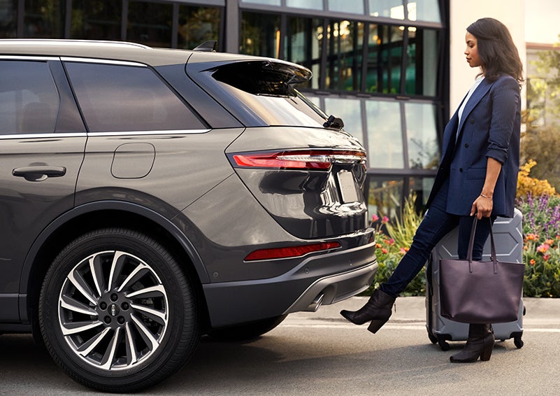 A woman with her hands full uses her foot to activate the available hands-free liftgate. | Empire Lincoln of Huntington in Huntington NY