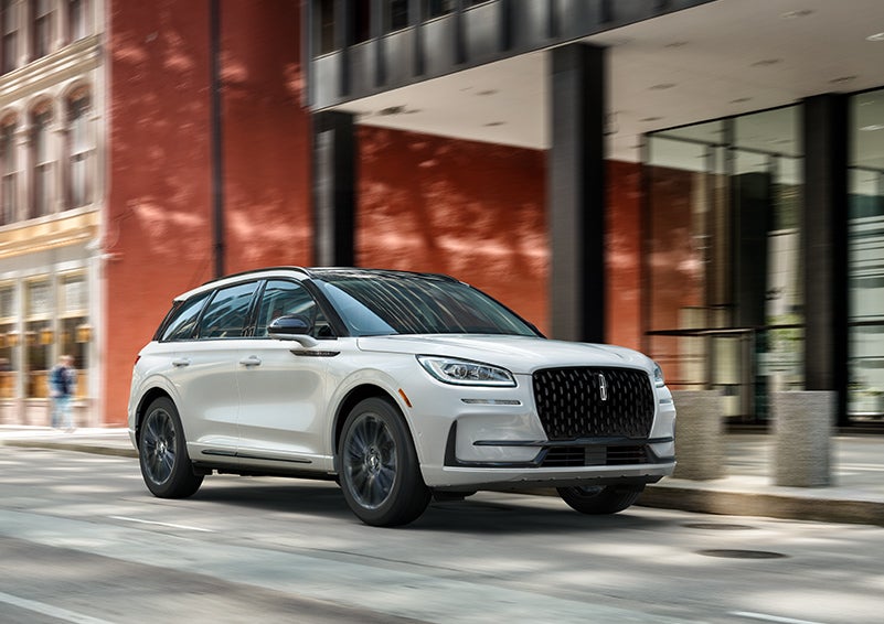 The 2024 Lincoln Corsair® SUV with the Jet Appearance Package and a Pristine White exterior is parked on a city street. | Empire Lincoln of Huntington in Huntington NY