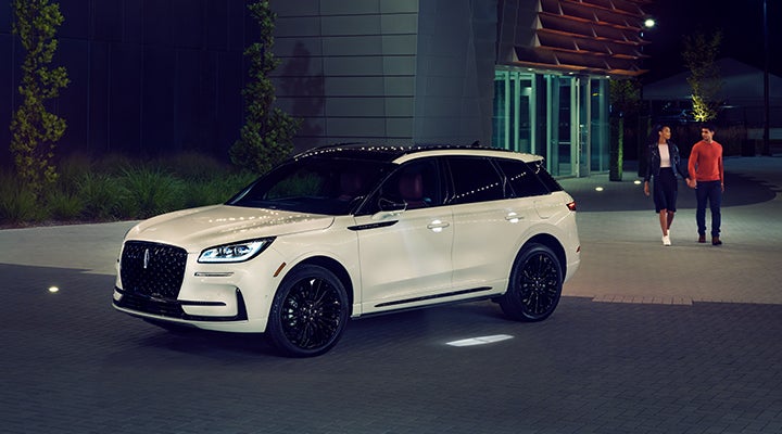 Two people approach a 2024 Lincoln Corsair® SUV featuring the available Jet Appearance Package. | Empire Lincoln of Huntington in Huntington NY