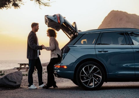 A couple share a moment together outside a 2025 Lincoln Corsair® SUV near the open liftgate. | Empire Lincoln of Huntington in Huntington NY
