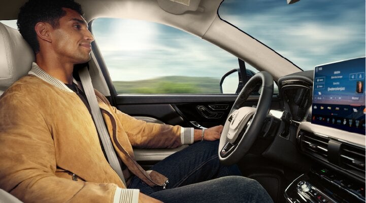 A person is shown using Lincoln BlueCruise hands-free highway driving technology on a divided highway called a Hands-Free Blue Zone. | Empire Lincoln of Huntington in Huntington NY