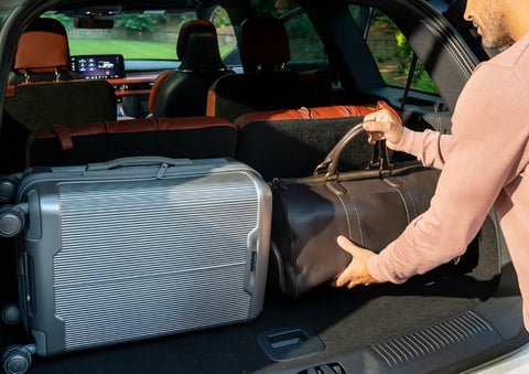 A man loads luggage into the rear of a 2026 Lincoln Aviator® SUV through the opened rear liftgate. | Empire Lincoln of Huntington in Huntington NY