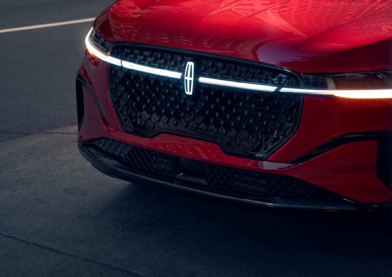 The available front LED light bar and center Lincoln Star logo glow at dusk. | Empire Lincoln of Huntington in Huntington NY