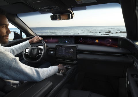 A driver of a parked 2026 Lincoln Nautilus® SUV takes a relaxing moment at a seaside overlook while inside his Nautilus. | Empire Lincoln of Huntington in Huntington NY