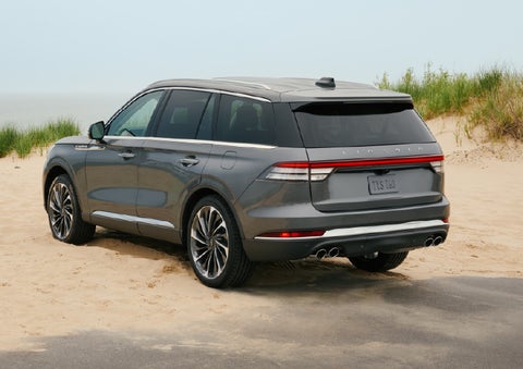 A 2027 Lincoln Aviator® SUV is parked next to sand dunes. | Empire Lincoln of Huntington in Huntington NY