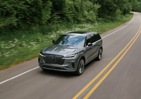 A 2027 Lincoln Aviator® SUV is being driven down a road. | Empire Lincoln of Huntington in Huntington NY