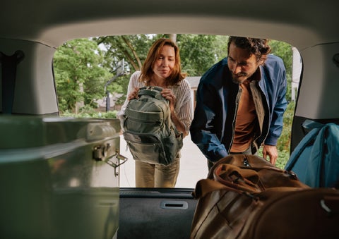A couple loads luggage into the rear of a 2027 Lincoln Aviator® Black Label™ SUV..e 202 | Empire Lincoln of Huntington in Huntington NY