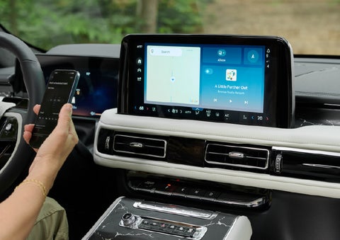 A person pairs thier phone with the center touchscreen of a 2027 Lincoln Aviator® Black Label™ SUV | Empire Lincoln of Huntington in Huntington NY